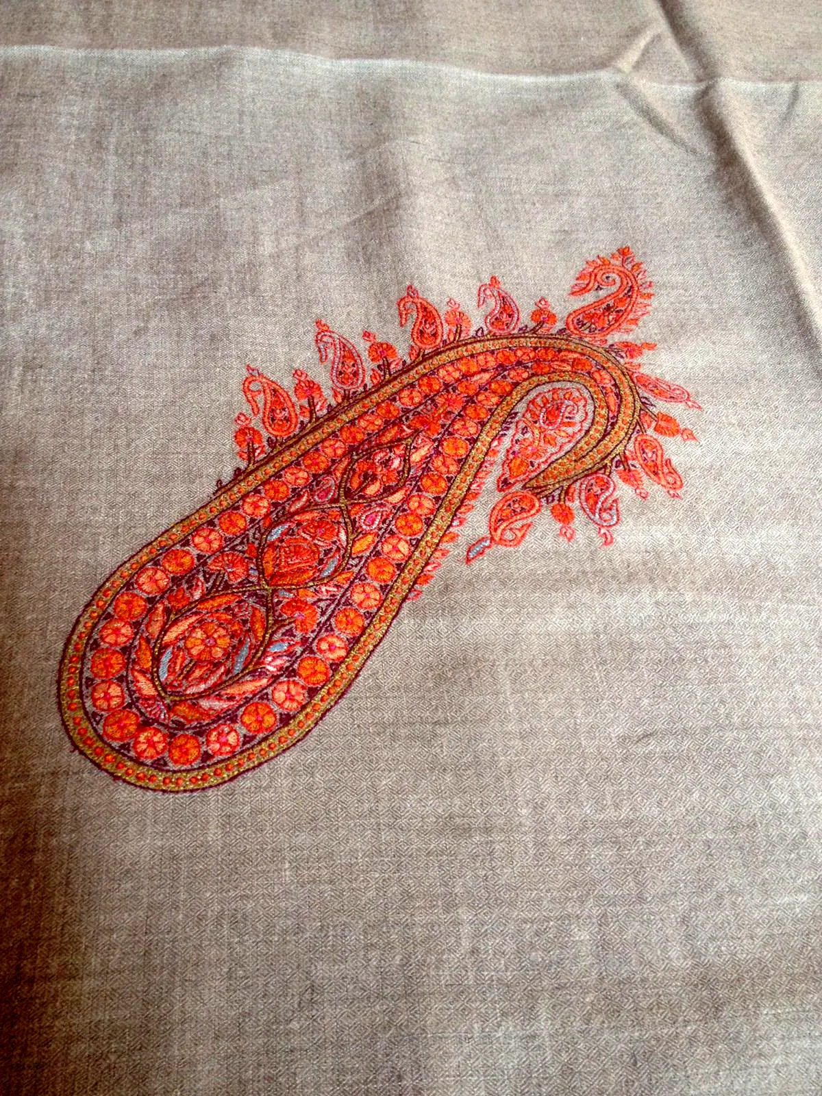 A single orange and red paisley embroidered on plain grey pashmina.