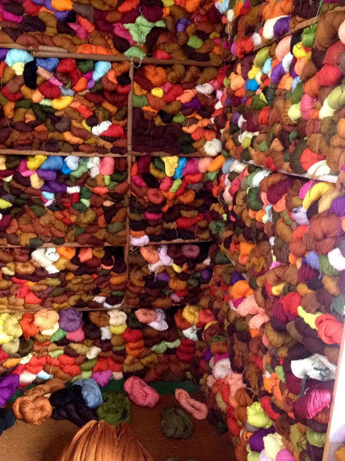 Shelves packed with skeins of dyed yarn in every colour.