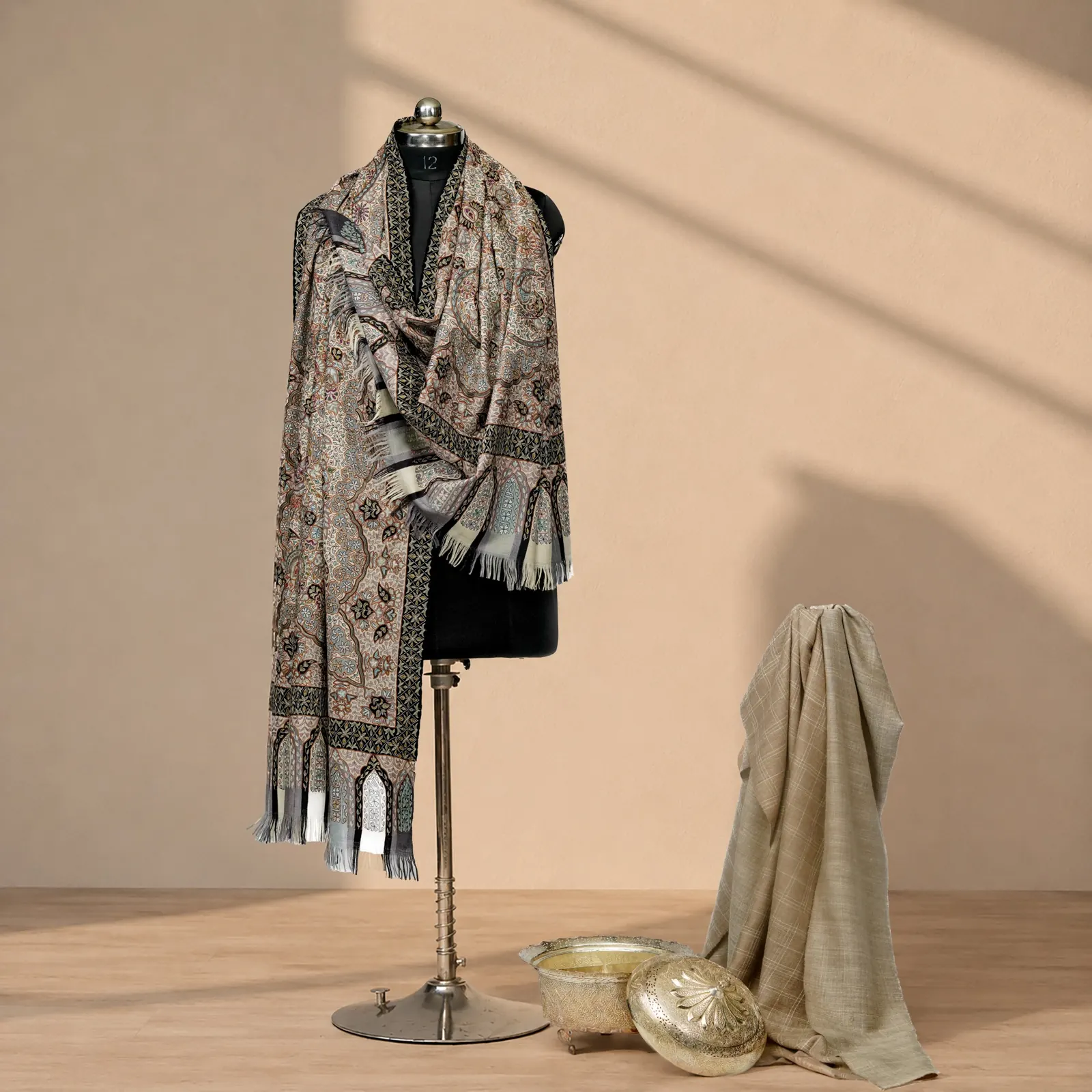 Muted grey and stone paisley shawl with a dark patterned border and tasselled ends.