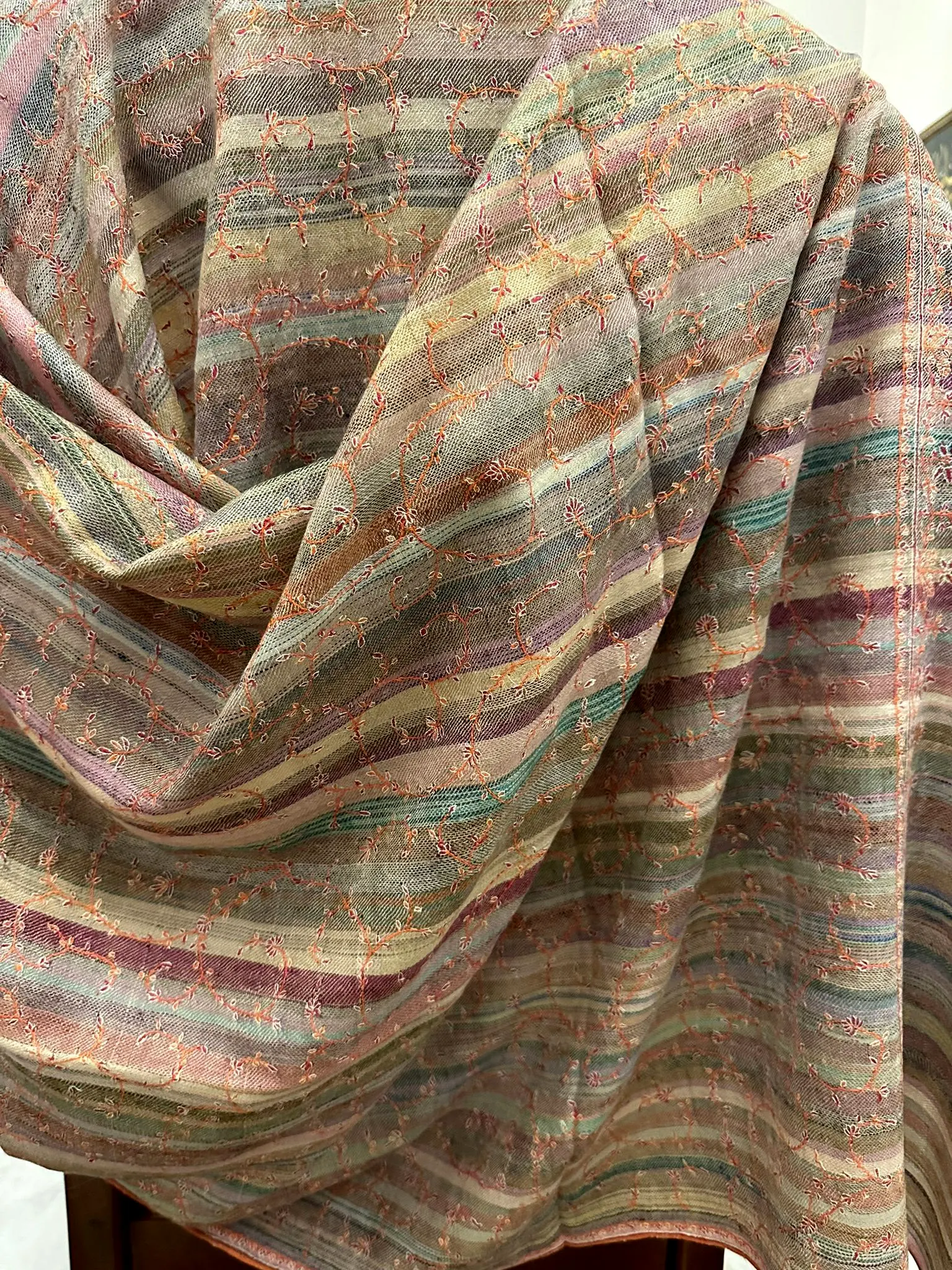 Shawl in muted rose, sage and grey stripes with fine needlework, draped.
