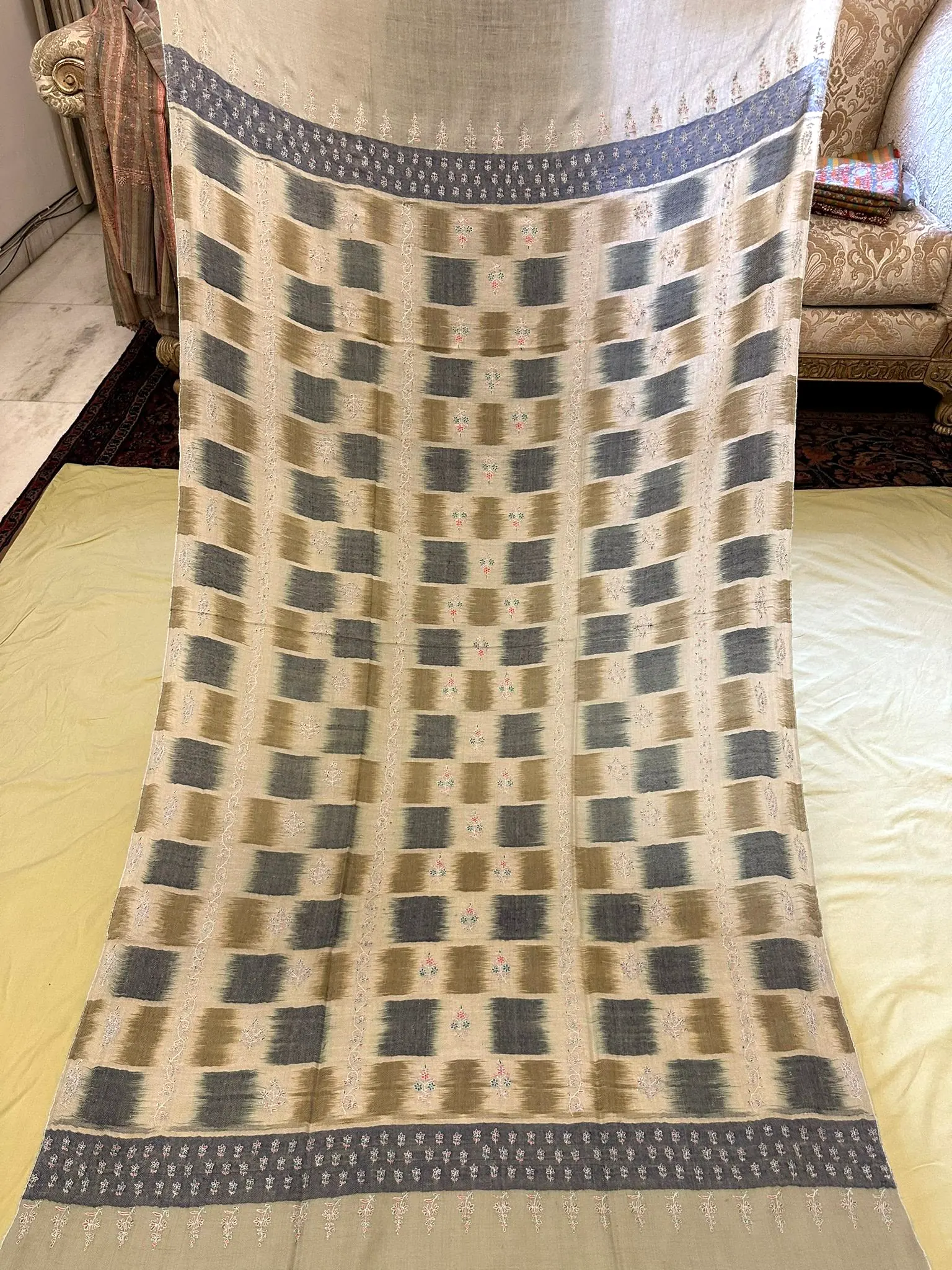 The same shawl laid out full length, showing the ikat blocks and patterned ends.