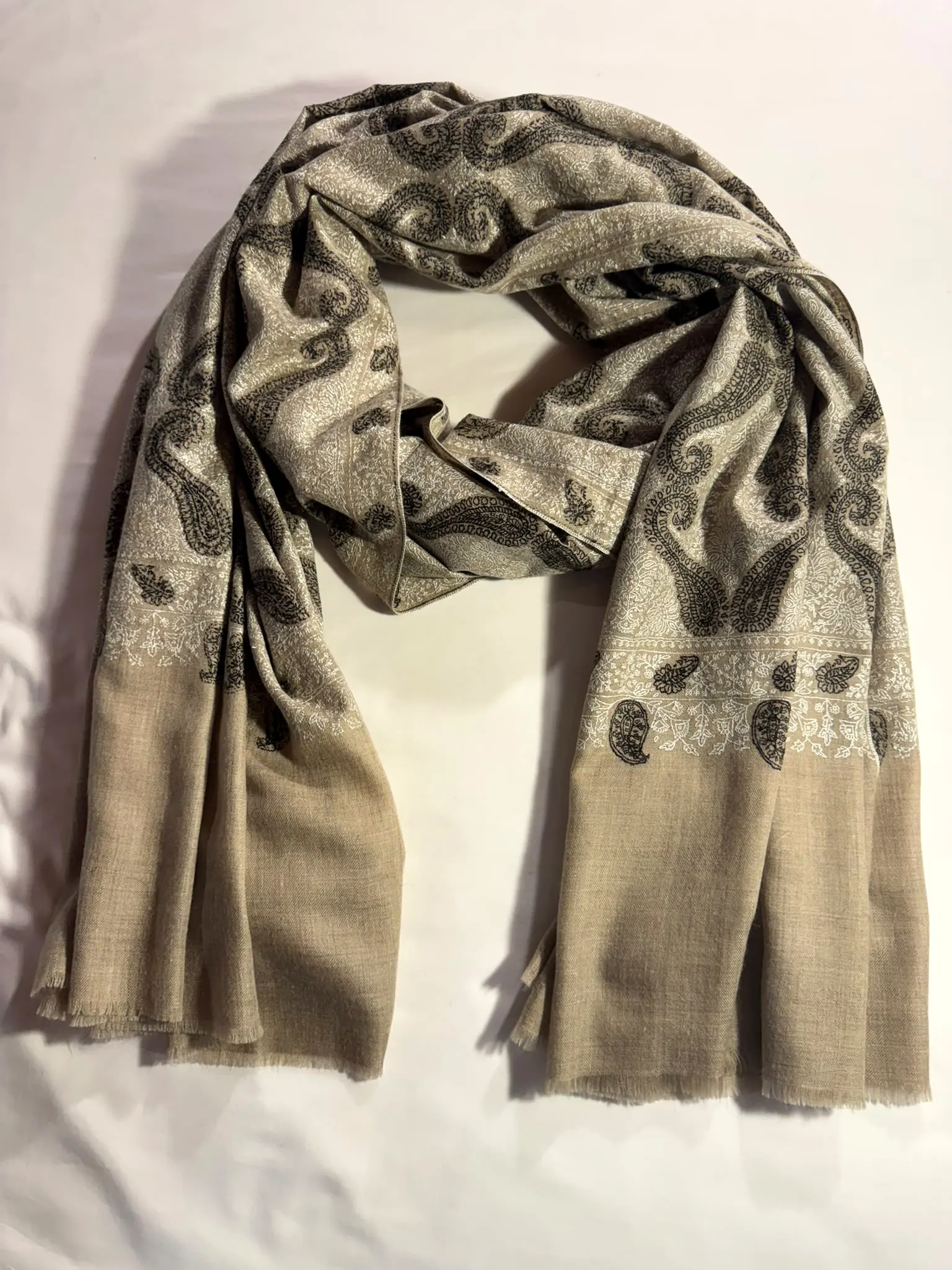 Shawl with grey paisley needlework over the body and plain beige ends.