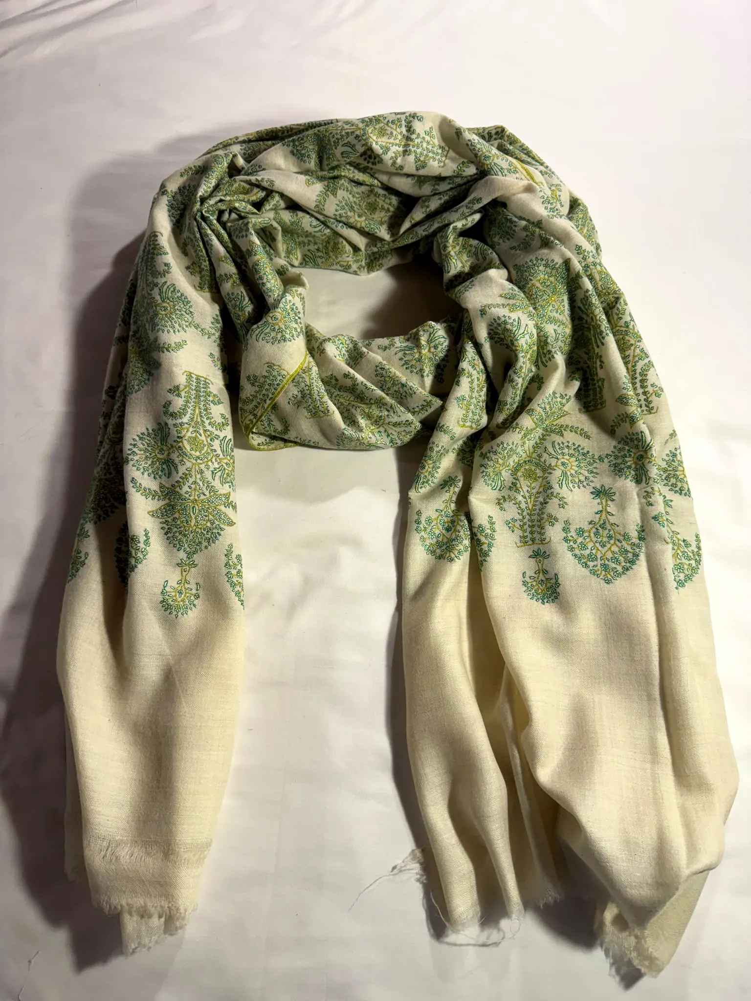Ivory shawl with green paisley needlework at both ends.