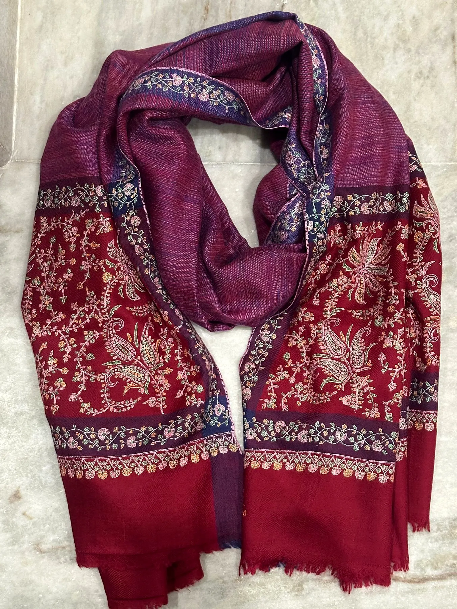 Plum stole with dense crimson and ivory needlework ends.