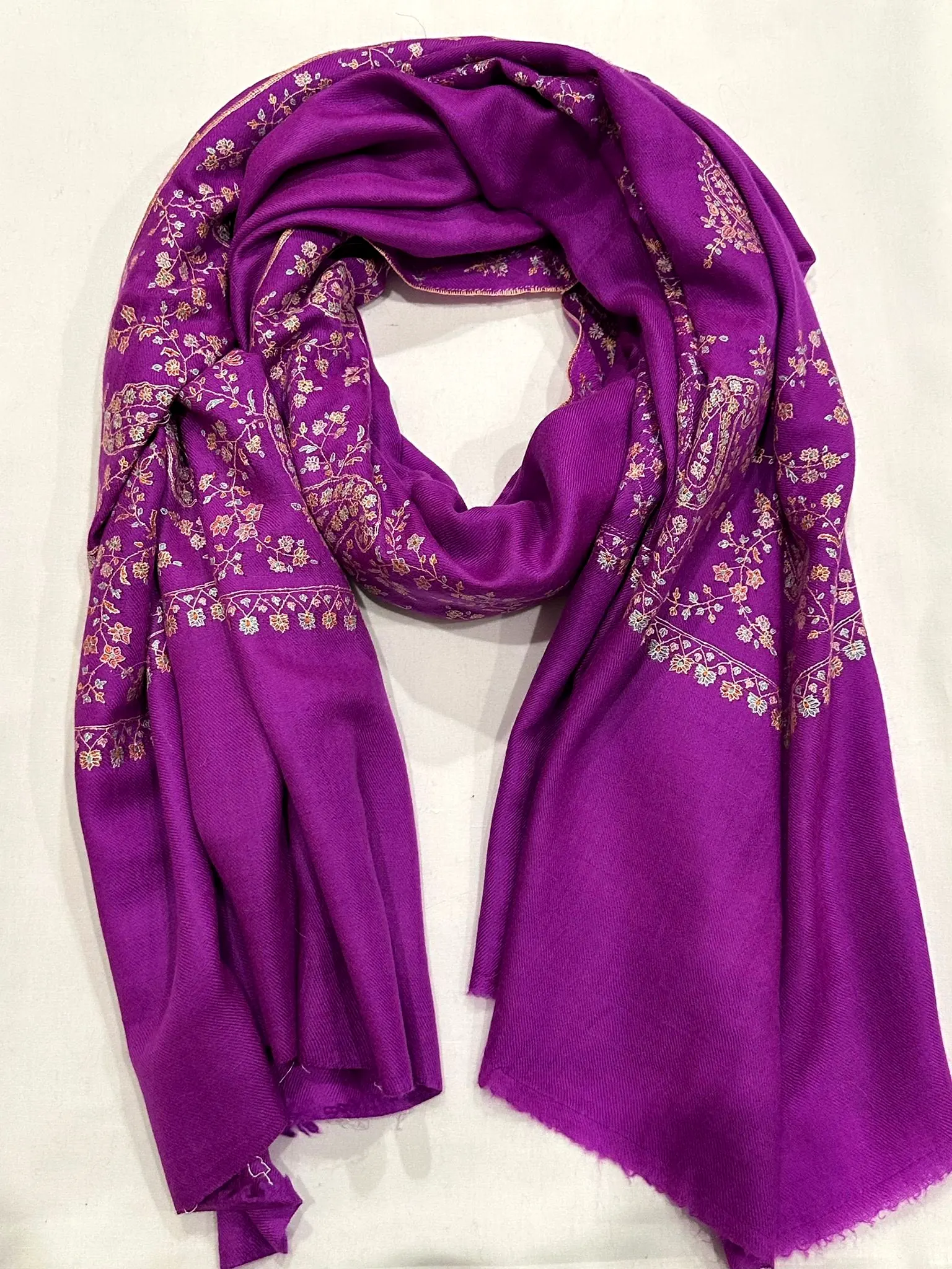 Purple stole with dense pink and ivory needlework borders.