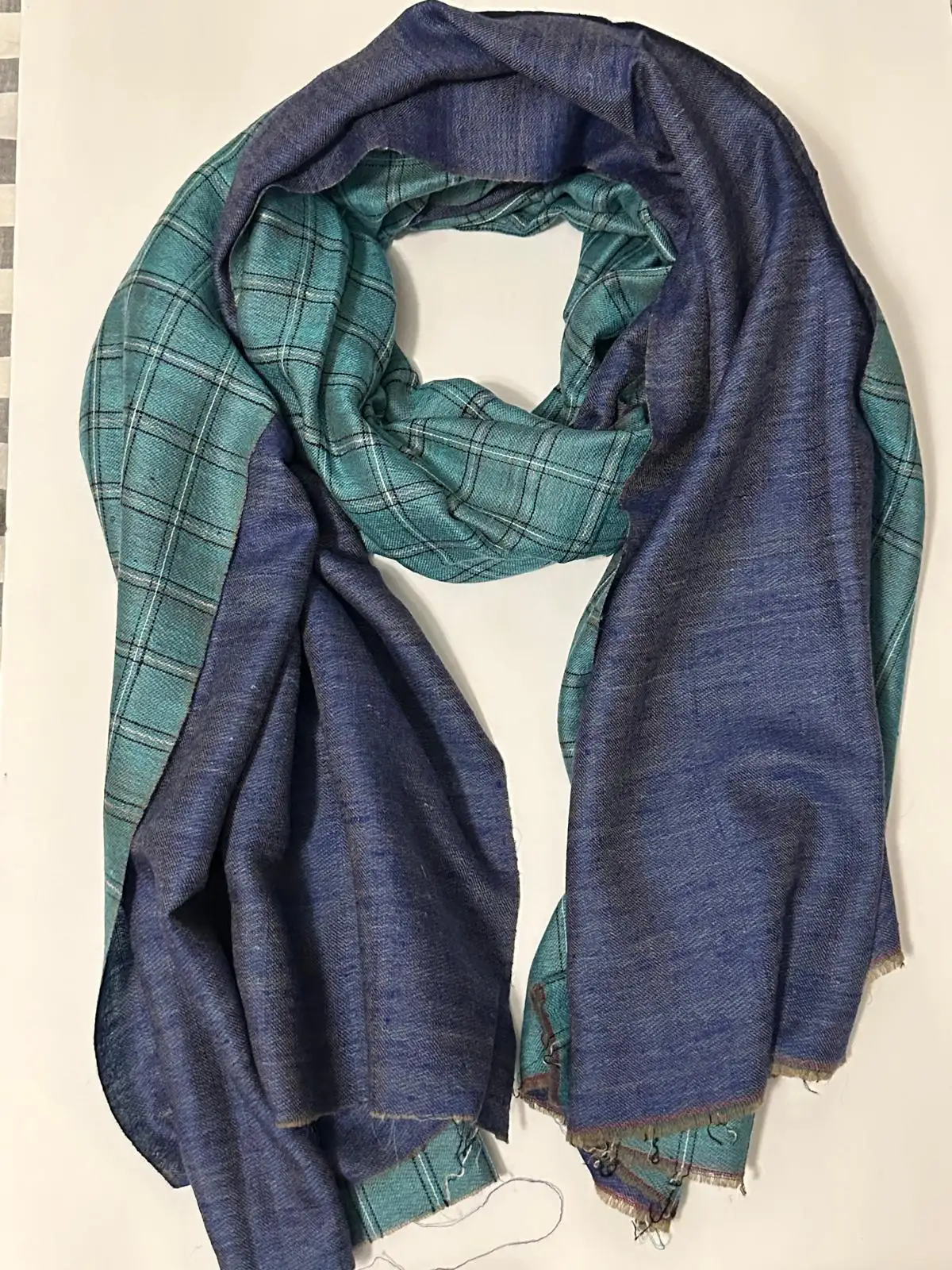 Reversible stole with a teal check on one face and plain indigo on the other.