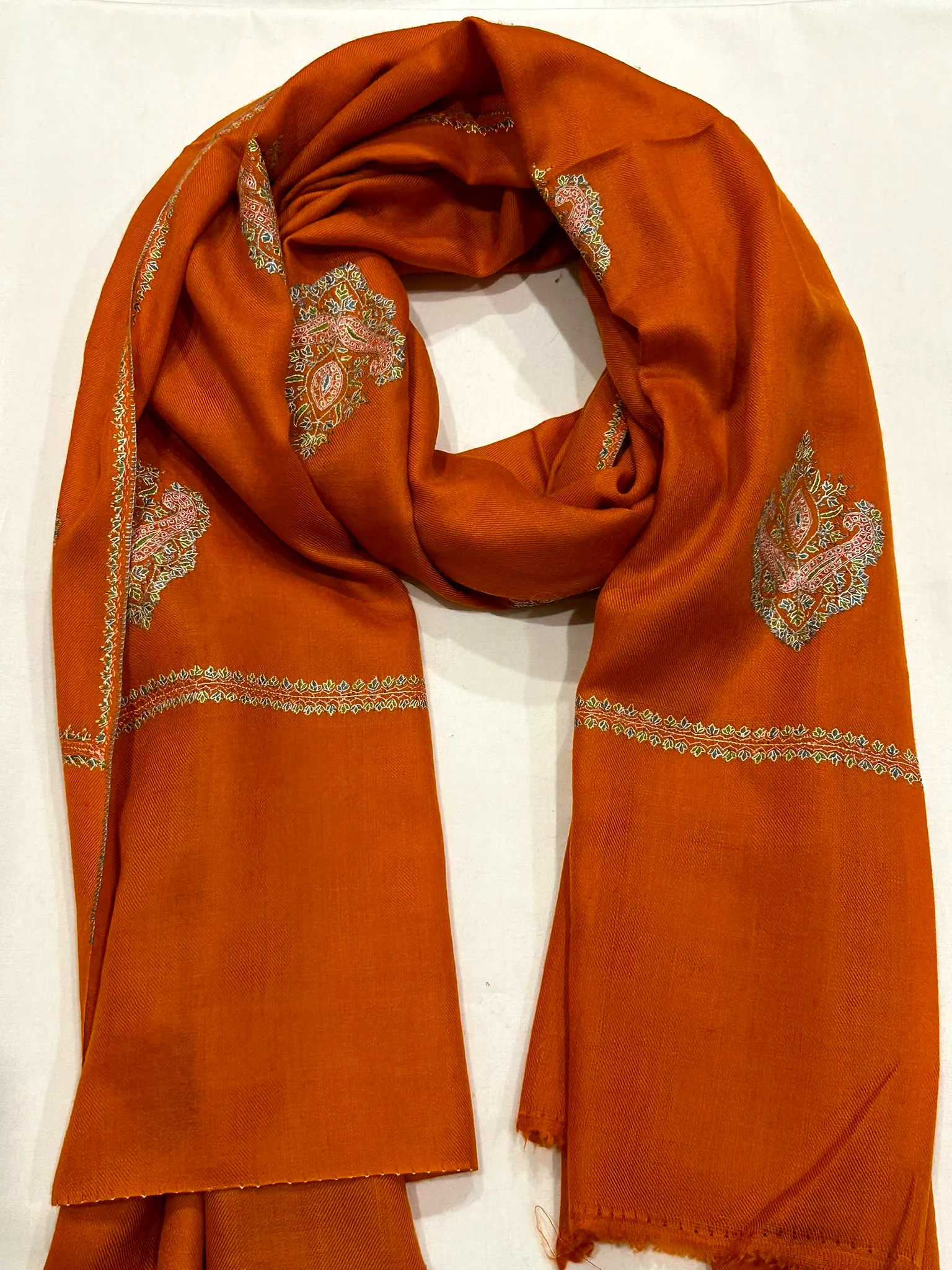 Burnt orange stole with tonal paisley needlework and ivory borders.